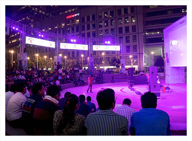 Outdoor evening event with stage lighting and audience